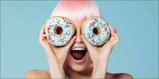 Image of young woman looking through donut holes