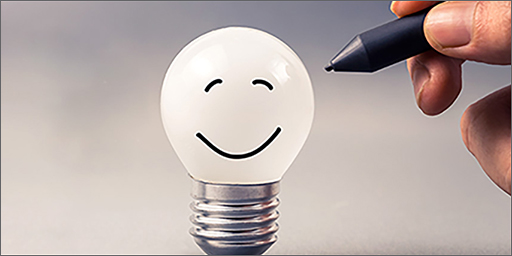 Image of lightbulb with with happy face on it.